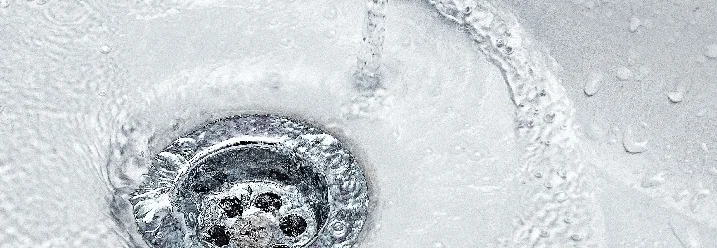 Wasser fließt in einen Abfluss