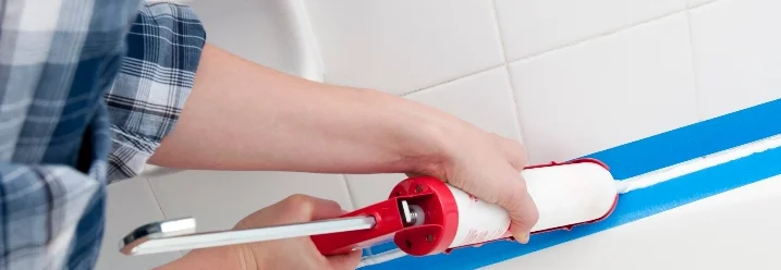 Person versiegelt Fuge mit Dichtmittelpistole