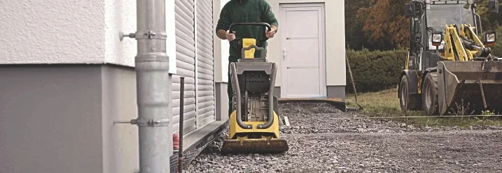 Person mit Rüttelplatte