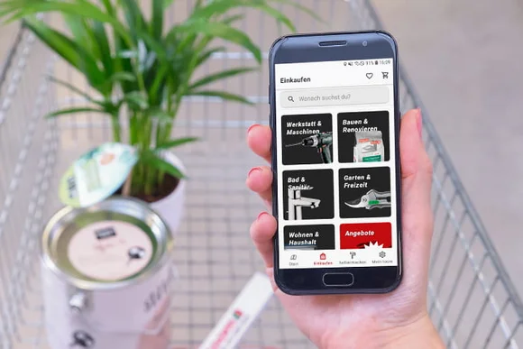 Eine Person hält ein Smartphone mit einer Einkaufs-App in der Hand.