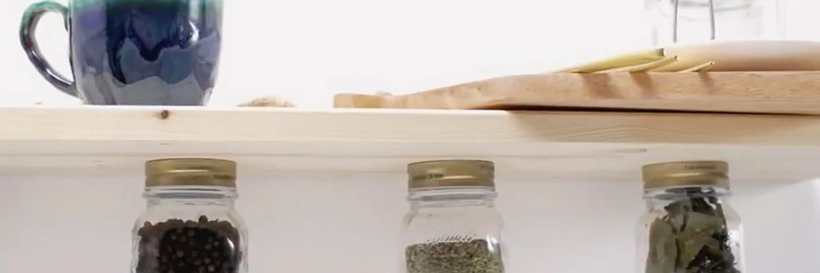 Gewürzgläser unter einem Holzregal