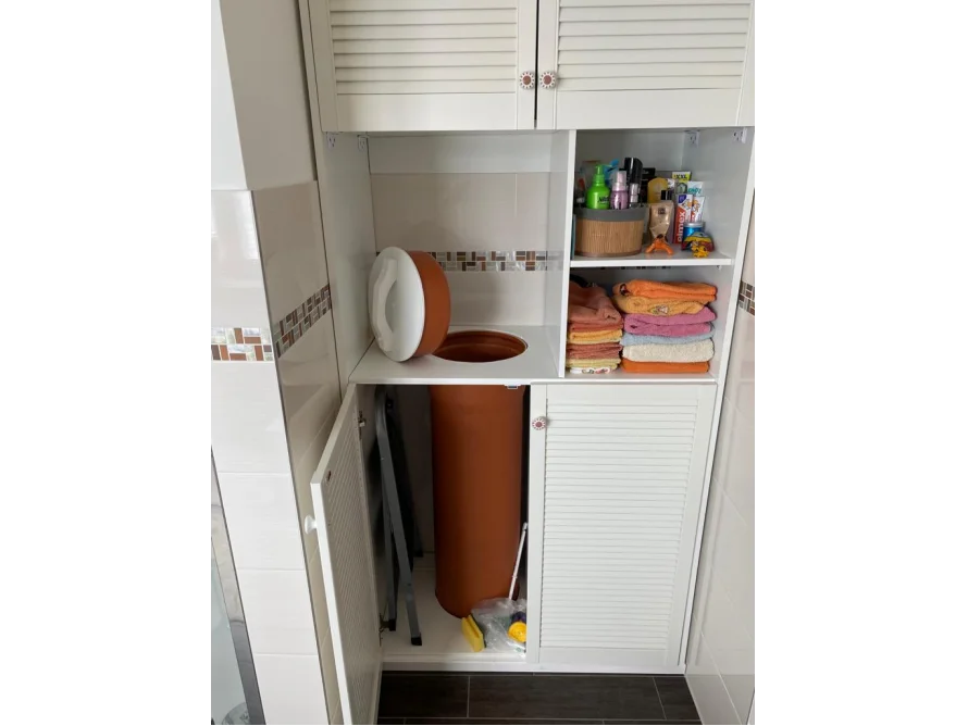 Offener weißer Badezimmerschrank mit Regalen