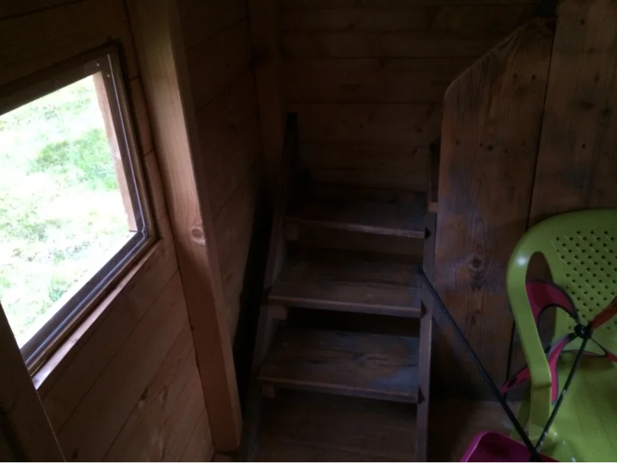 Holztreppe und Fenster in einem Gartenhaus