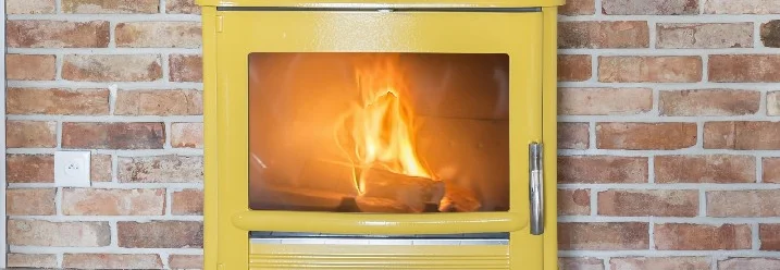 Gelber Kaminofen mit brennendem Feuer