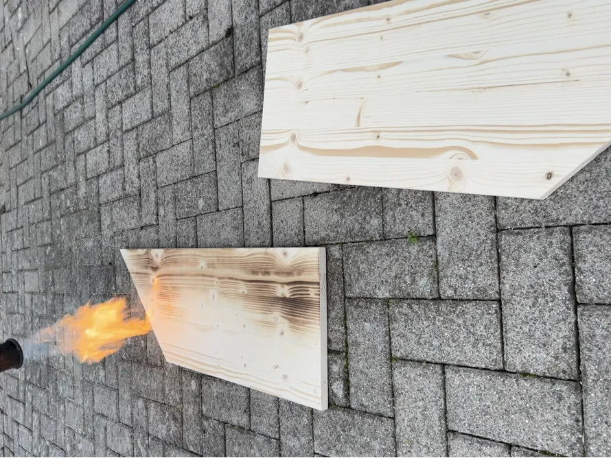 Zwei Holzbretter, eines wird abgeflämmt