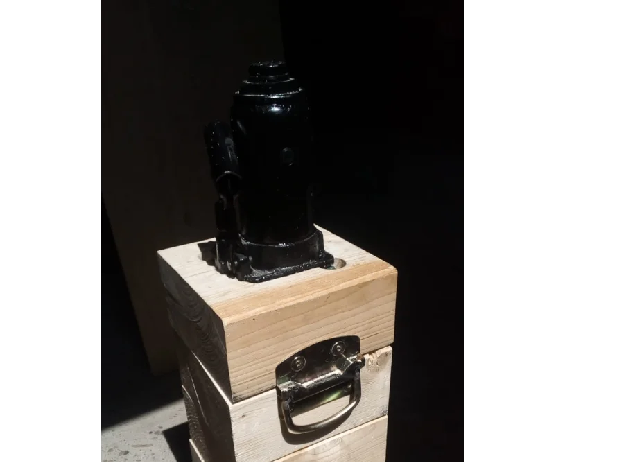 Schwarzer Wagenheber auf Holzkonstruktion