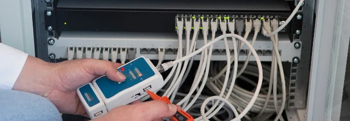 Person testet Netzwerkverkabelung