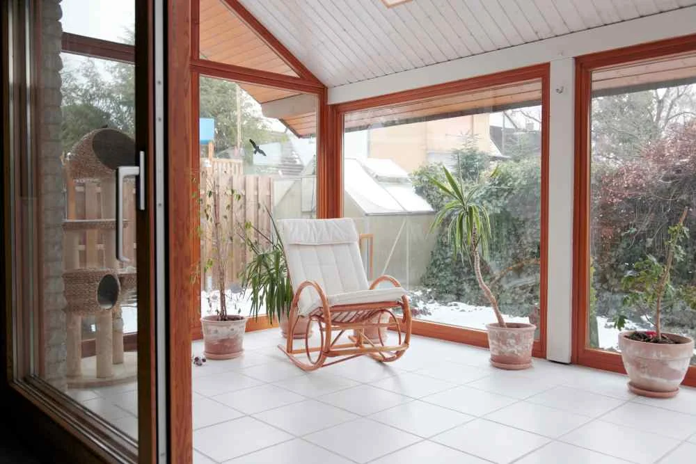 moderner Wintergarten mit Glasschiebetür und Schaukelstuhl