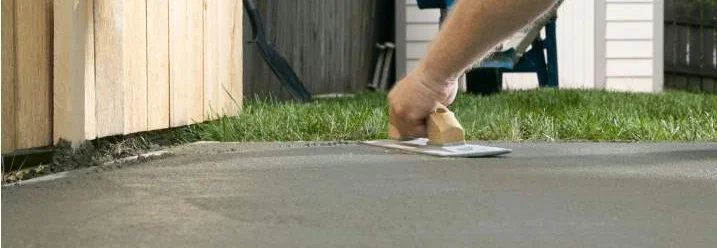 Person glättet Beton mit Glättkelle.