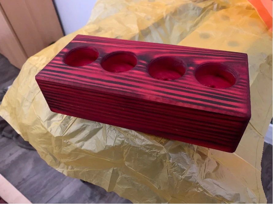 Roter Holzblock mit vier runden Vertiefungen