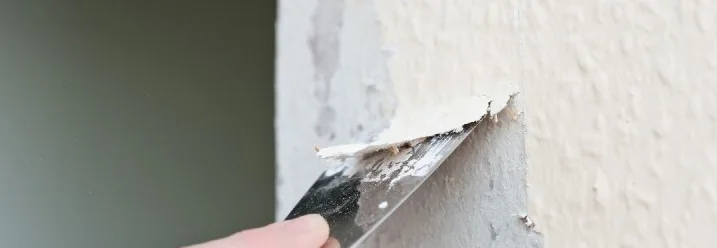 Hand entfernt Tapete mit Spachtel