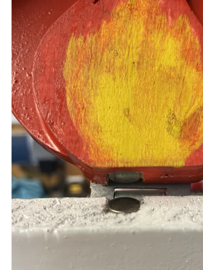 Rote und gelbe Holzoberfläche mit Metallscharnier