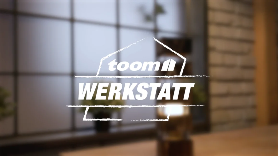 toom Werkstatt Logo mit unscharfer Leuchte im Hintergrund