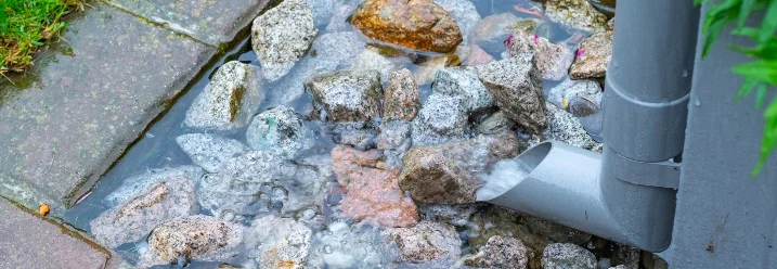Regenrinne leitet Wasser auf Steine