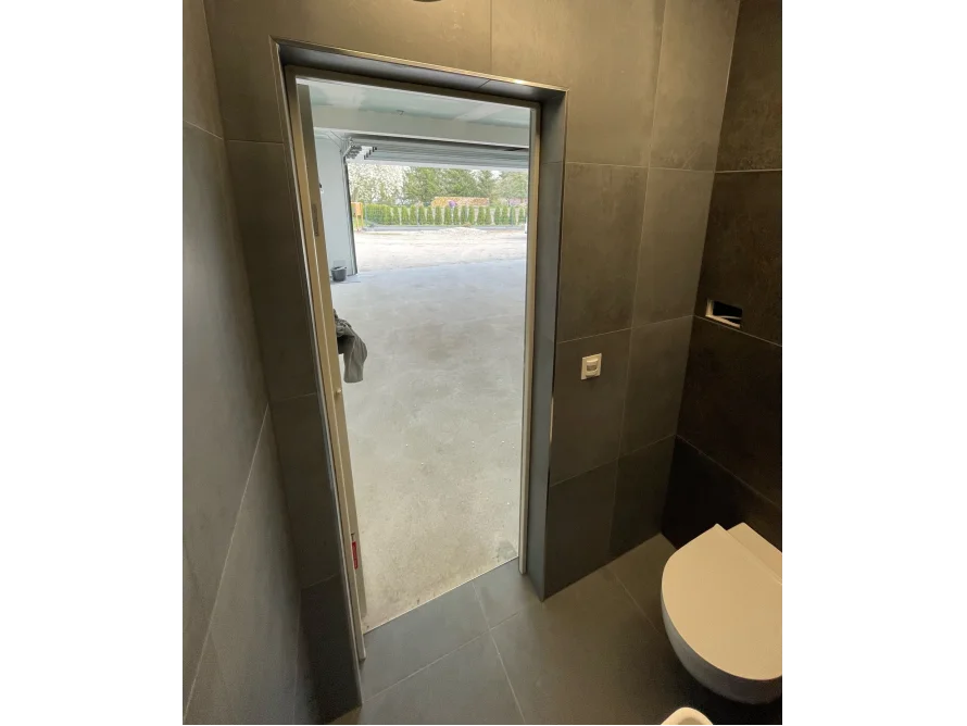 Badezimmer mit offener Tür zur Garage