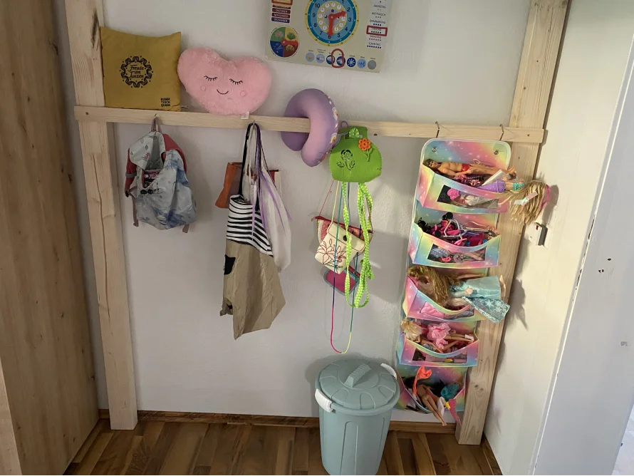 Kleiderstange mit Taschen und Spielzeug