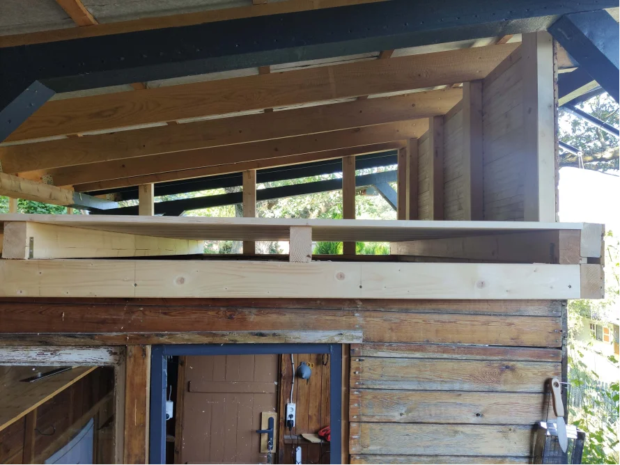 Rohbau eines Holzanbaus auf einer bestehenden Hütte aus Holz.