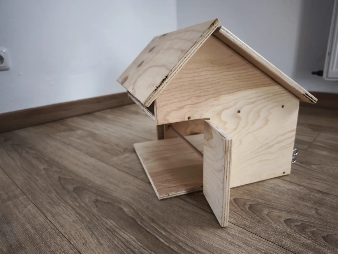 Ein kleiner Holzstall für Kinderspielzeug.