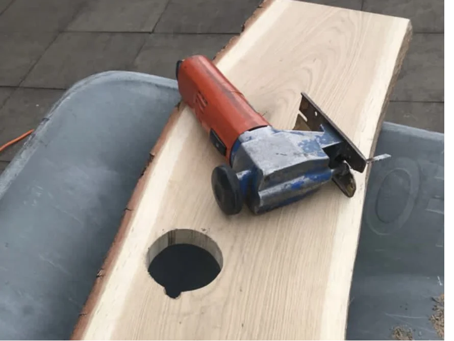Stichsäge auf Holzbrett mit Loch