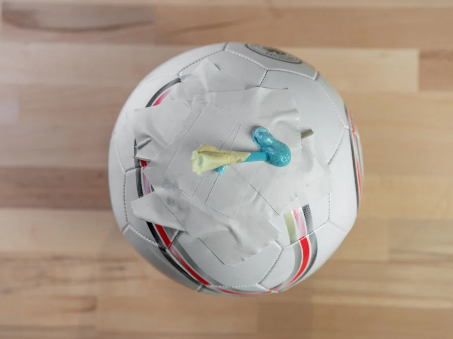 Fußball mit Klebeband und Klebstoff repariert