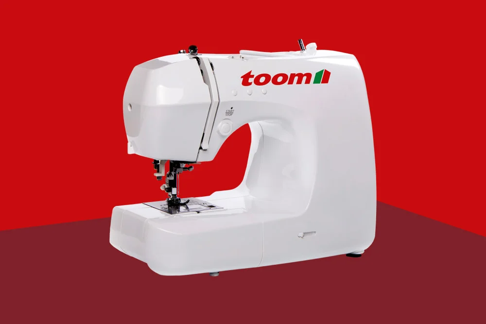 Weiße Nähmaschine von toom vor rotem Hintergrund.