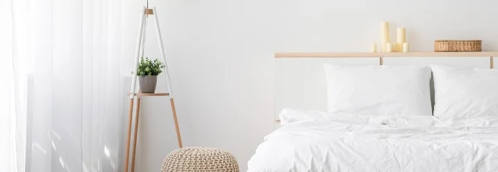 Helles, minimalistisches Schlafzimmer mit Bett und Stehlampe