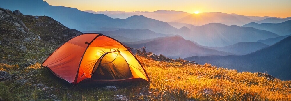 Zelt im Gebirge bei Sonnenuntergang