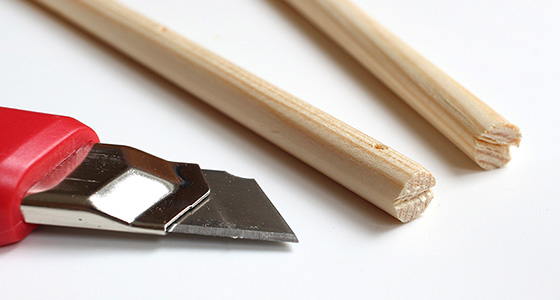 Zwei Holzstäbe und ein Teppichmesser