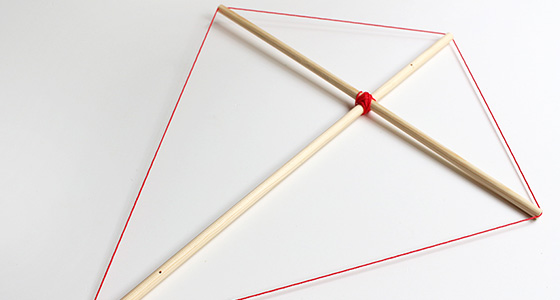 Drachenkreuz aus Holz mit roter Schnur